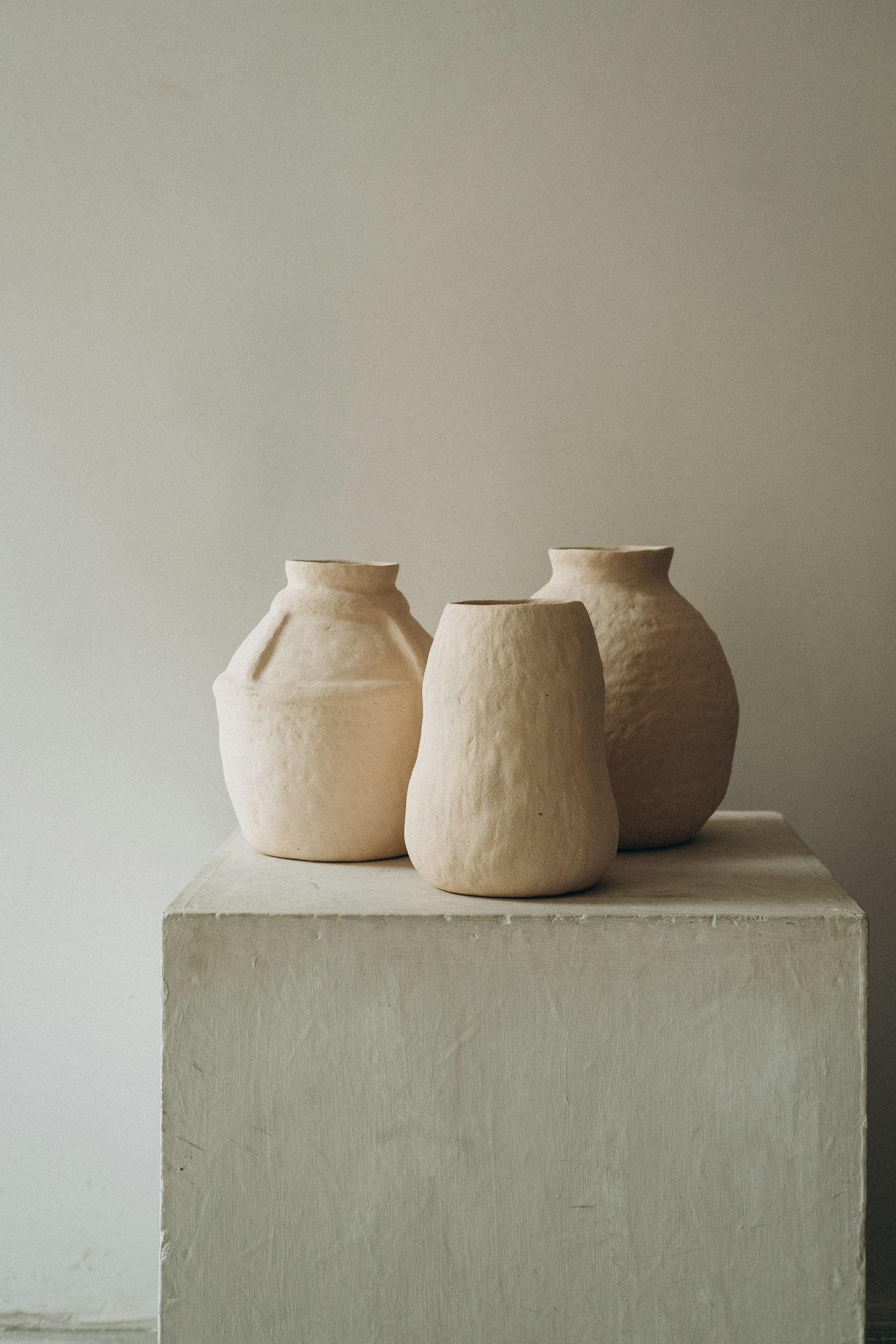 Trois vases en grès clair aux formes irrégulières