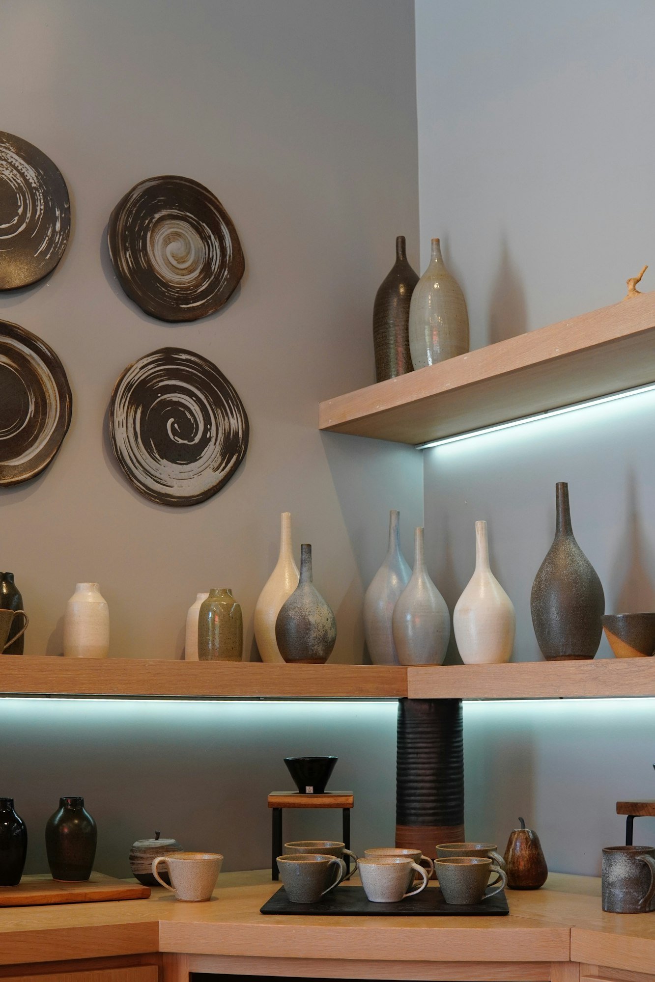 Des étagères de vases et d’assiettes en grès dans une boutique