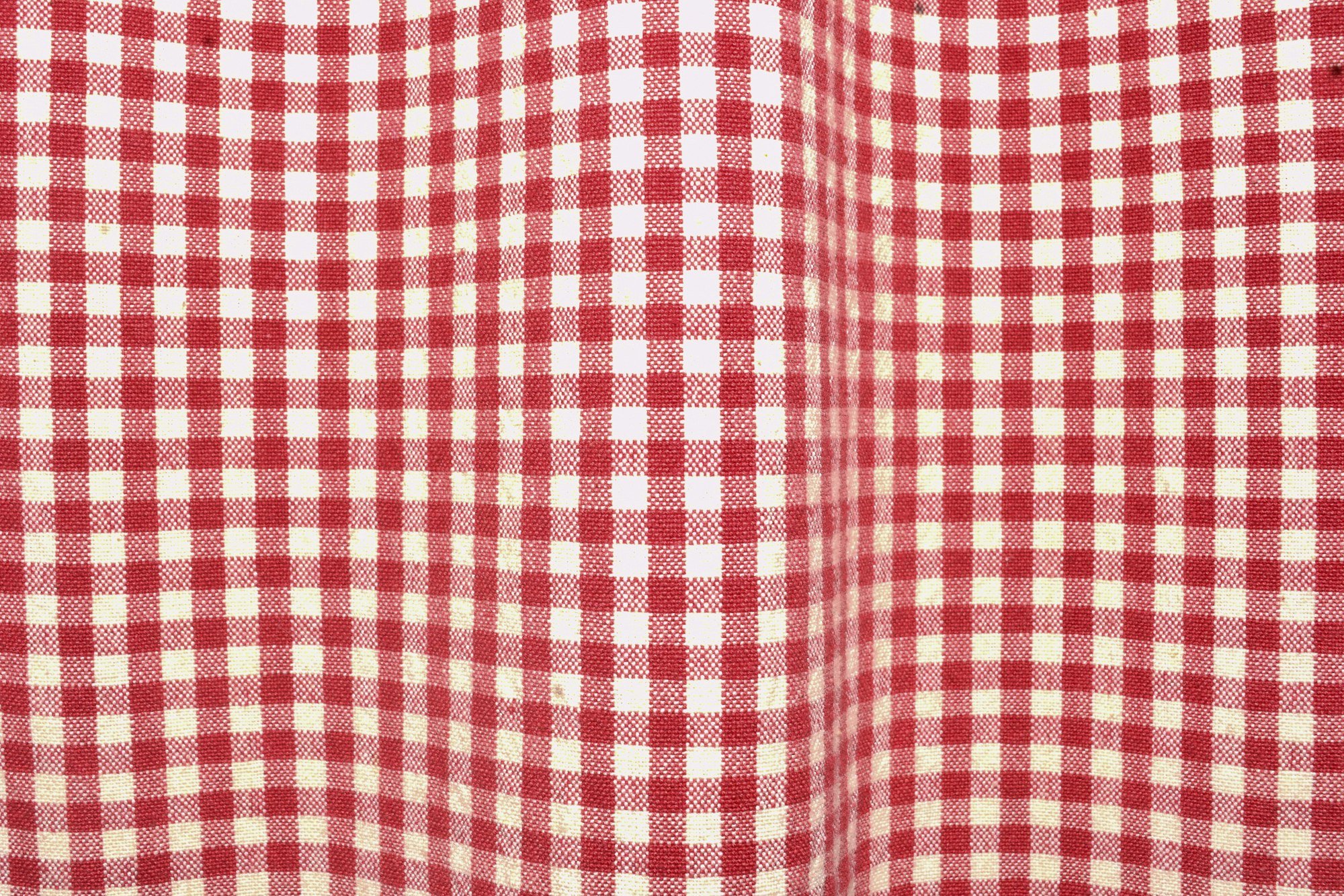 Le tissage à petits carreaux rouges et blancs d’une nappe