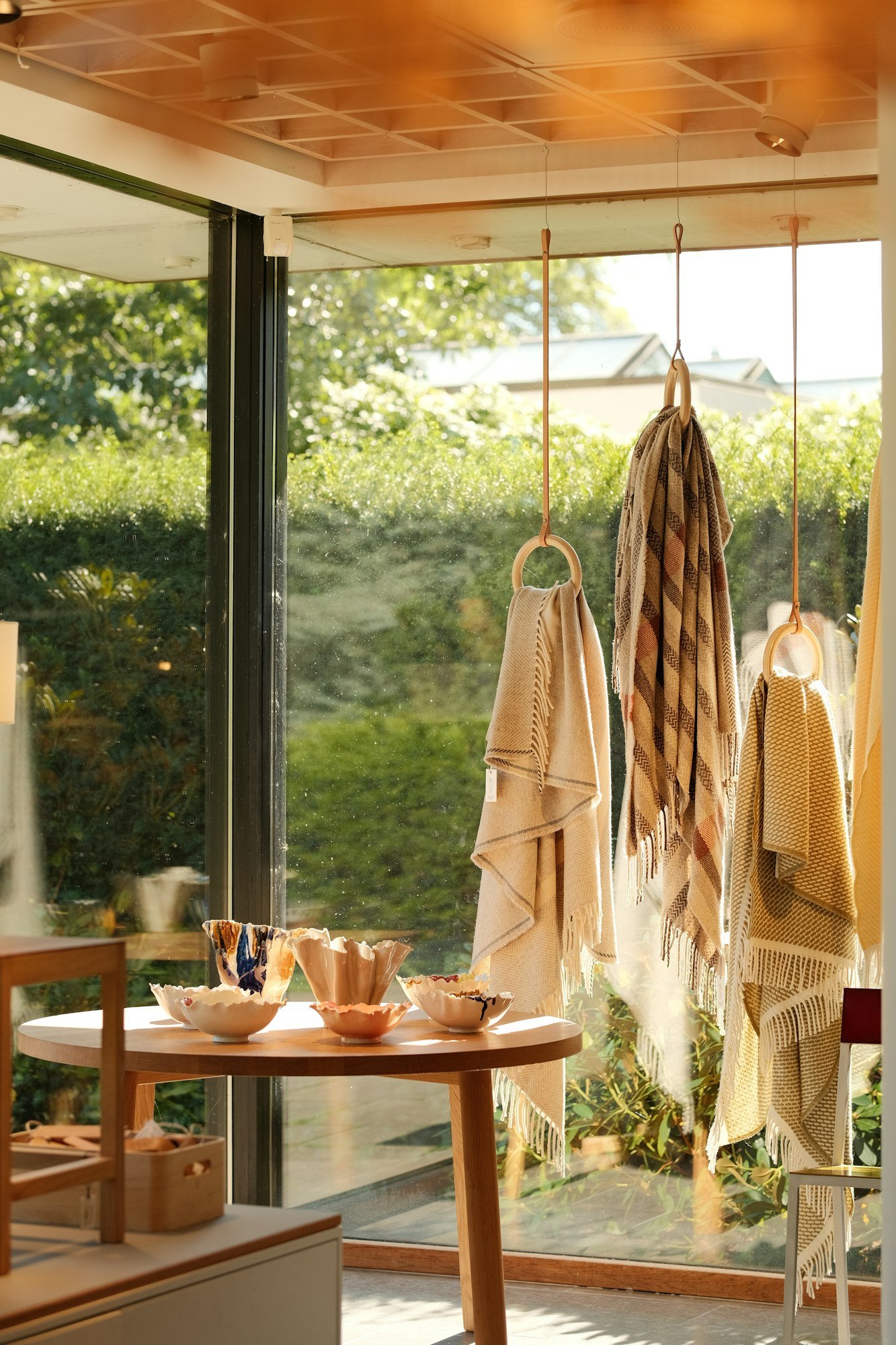 Du linge suspendu et des bols exposés près d’une grande fenêtre