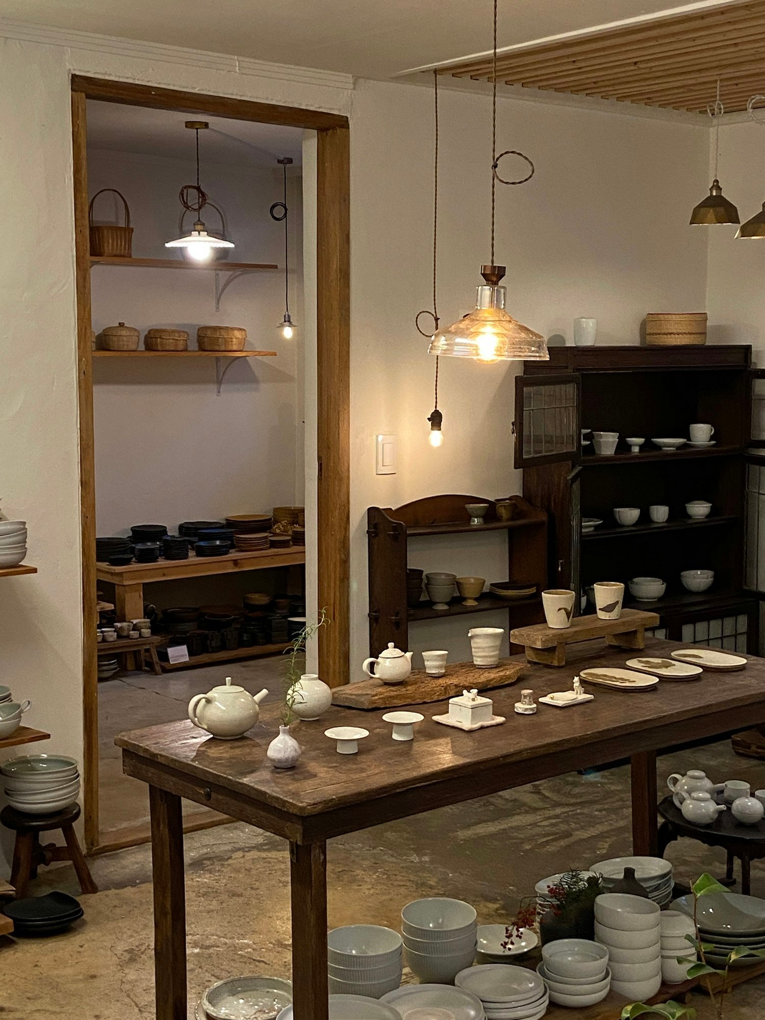 Une grande table chargée de bols et d’assiettes, au fond d’une boutique