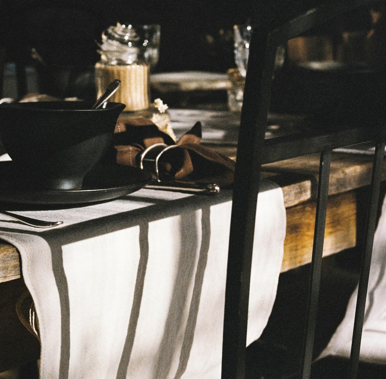 Un chemin de table en lin rayé qui retombe d’une table en bois